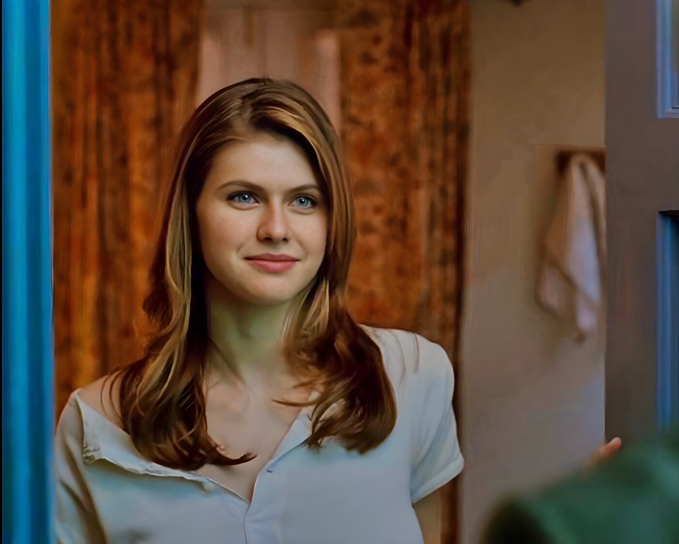 Alexandra Daddario stands confidently during a scene in True Detective, with her long dark hair framing her face and her striking blue eyes directed toward the camera.